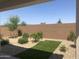 Backyard with desert landscaping including a green turf accent, bushes, and a block wall at 25109 N 173Rd Dr, Surprise, AZ 85387