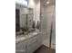 Bathroom showcasing double sinks, a granite countertop, white subway tile and a sleek glass-enclosed shower at 25109 N 173Rd Dr, Surprise, AZ 85387
