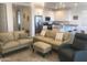 Open-concept living room with couches and modern kitchen, ideal for entertaining at 25109 N 173Rd Dr, Surprise, AZ 85387