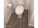 A toilet room with neutral walls, modern toilet, a gray rug, and wood-look tiled flooring at 25109 N 173Rd Dr, Surprise, AZ 85387