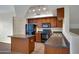 Modern kitchen featuring an island, dark wood cabinetry, and black appliances at 280 S Evergreen Rd # 1296, Tempe, AZ 85288