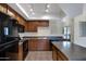 Modern kitchen featuring an island, dark wood cabinetry, and black appliances at 280 S Evergreen Rd # 1296, Tempe, AZ 85288