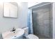 Bathroom featuring a vanity sink, toilet, and walk-in shower with gray tiles at 3115 N 55Th Ave, Phoenix, AZ 85031