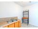 Convenient kitchenette area with wooden cabinets, double sink, and an ornate metal shelving unit at 3115 N 55Th Ave, Phoenix, AZ 85031