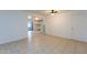 Spacious living room featuring neutral tile flooring, ceiling fan, and view to kitchen at 3115 N 55Th Ave, Phoenix, AZ 85031