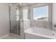 Stylish bathroom featuring a glass-enclosed shower, soaking tub, and a view to the outdoors at 31822 N Bandit Rd, San Tan Valley, AZ 85143