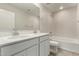 Well-lit bathroom featuring double sinks, white cabinetry, and a shower over tub with white marble surround at 31822 N Bandit Rd, San Tan Valley, AZ 85143