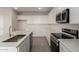 Sleek kitchen boasting stainless steel appliances, white cabinets, and quartz countertops at 31822 N Bandit Rd, San Tan Valley, AZ 85143