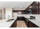 Modern kitchen featuring an island, stainless steel appliances, dark cabinets, and wood-look tile flooring at 31850 N Bandit Rd, San Tan Valley, AZ 85143