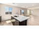 Open kitchen concept featuring island, stainless steel sink, wood-look tile flooring, and natural light at 31850 N Bandit Rd, San Tan Valley, AZ 85143