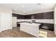 Modern kitchen with stainless steel appliances, dark cabinets, a white countertop, and a kitchen island at 31850 N Bandit Rd, San Tan Valley, AZ 85143