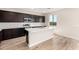Modern kitchen featuring an island, stainless steel appliances, dark cabinets, and wood-look tile flooring at 31850 N Bandit Rd, San Tan Valley, AZ 85143