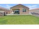 Spacious backyard with lush green grass, a covered patio with a grill, and a cute playhouse at 3597 E Henson St, San Tan Valley, AZ 85140