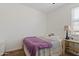 Cozy bedroom with a window, a bed with a purple blanket, and a side table with a lamp at 3597 E Henson St, San Tan Valley, AZ 85140