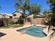 Backyard with hot tub, artificial grass, desert landscaping, and privacy fence at 4034 E Anderson Dr, Phoenix, AZ 85032
