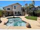 Landscaped backyard with a hot tub surrounded by a stone patio and tropical plants at 4034 E Anderson Dr, Phoenix, AZ 85032