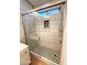 Modern shower with sleek tile walls, patterned floor, and glass door with a rain shower head at 4034 E Anderson Dr, Phoenix, AZ 85032