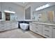 Modern bathroom featuring a soaking tub, dual sinks, and a barn door closet at 40613 N Candlewyck Ln, Anthem, AZ 85086