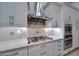 The kitchen boasts stainless steel appliances, gas cooktop, custom cabinetry, and elegant backsplash at 40613 N Candlewyck Ln, Anthem, AZ 85086