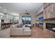 Cozy living room with a fireplace, a large sectional sofa, and an open layout connecting to the kitchen at 40613 N Candlewyck Ln, Anthem, AZ 85086