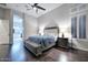 Comfortable bedroom with hardwood floors, neutral walls, and a large window with plantation shutters at 40613 N Candlewyck Ln, Anthem, AZ 85086