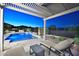 Relaxing poolside view with comfortable lounge chairs under a shaded pergola overlooking the serene backyard at 40613 N Candlewyck Ln, Anthem, AZ 85086