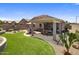 Landscaped backyard with a covered patio, dining area, artificial turf, and desert landscaping at 4230 W Palace Station Rd, New River, AZ 85087