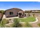 Landscaped backyard with a covered patio, dining area, artificial turf, and desert landscaping at 4230 W Palace Station Rd, New River, AZ 85087