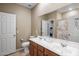 Bright bathroom featuring double sinks, large mirror, tile flooring, and shower with tile surround at 4230 W Palace Station Rd, New River, AZ 85087