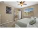 Bright bedroom with a ceiling fan, large window, and walk-out access at 4230 W Palace Station Rd, New River, AZ 85087