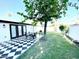 Relaxing backyard patio with a black and white checkered tile, dining set, grill, and a well-manicured lawn at 541 W Marlette Ave, Phoenix, AZ 85013