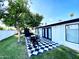 Outdoor patio featuring a black and white checkered floor, dining area, grill, and a spacious grassy backyard at 541 W Marlette Ave, Phoenix, AZ 85013