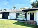 This home has white brick and a black trim, showcasing a well-manicured lawn and detailed landscaping at 541 W Marlette Ave, Phoenix, AZ 85013