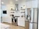 Modern kitchen with stainless steel appliances, white cabinets, and stylish floating shelves at 541 W Marlette Ave, Phoenix, AZ 85013