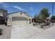 View of home with a two car garage, desert landscaping and sidewalk at 5418 W Carson Rd, Laveen, AZ 85339