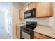 Kitchen featuring cabinets, black oven, and black microwave at 5418 W Carson Rd, Laveen, AZ 85339