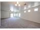 Large living room with plush carpeting, ceiling fan, and sliding glass doors to outdoor space at 5418 W Carson Rd, Laveen, AZ 85339