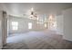 Expansive living room offering ample natural light, neutral carpeting, and access to adjacent rooms at 5418 W Carson Rd, Laveen, AZ 85339