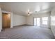 Comfortable living room featuring neutral carpeting, ceiling fan, and access to the patio at 5418 W Carson Rd, Laveen, AZ 85339