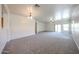 Expansive living room with plush carpeting, neutral walls, and natural light from sliding doors at 5418 W Carson Rd, Laveen, AZ 85339
