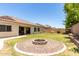 Backyard with gravel fire pit, grass lawn, and privacy fence at 6317 S Banning St, Gilbert, AZ 85298