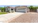 Long concrete driveway leads to a two-car garage, with low maintenance landscaping at 6317 S Banning St, Gilbert, AZ 85298