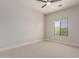 Neutral bedroom with beige carpet, ceiling fan, and view to trees outside the window at 742 W Vineyard Plains Dr, San Tan Valley, AZ 85143
