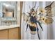 Cozy bathroom featuring a bee-themed shower curtain, single sink vanity and a framed mirror at 8103 E Southern Ave # 170, Mesa, AZ 85209