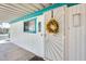 Close up of the front door with charming wreath, teal trim and security screen door at 8103 E Southern Ave # 170, Mesa, AZ 85209