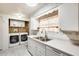 Bright kitchen featuring white cabinetry, stainless steel sink, and modern washer and dryer appliances at 8103 E Southern Ave # 170, Mesa, AZ 85209