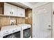 Laundry area featuring white cabinetry, storage shelving, and modern washer and dryer appliances at 8103 E Southern Ave # 170, Mesa, AZ 85209