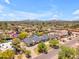 Expansive aerial view showcasing a home with lush landscaping and surrounding neighborhood, with mountain backdrop at 8213 E Sharon Dr, Scottsdale, AZ 85260