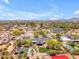 Stunning aerial view of a private estate featuring a pool, lush landscaping, a sport court and mountain views at 8213 E Sharon Dr, Scottsdale, AZ 85260