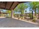 Inviting covered patio with brick pavers and a view of the lush backyard and swimming pool at 8213 E Sharon Dr, Scottsdale, AZ 85260